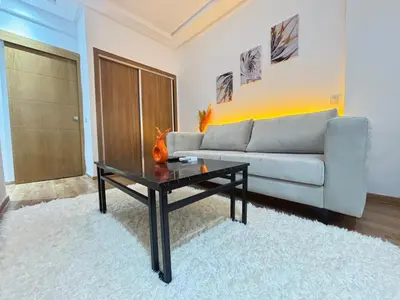 a living room with a couch and a coffee table at F2 Cozy and Swimming pool in Marrakech