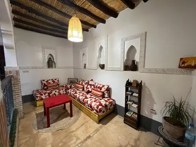a living room with two couches and a red stool at l'oasis de Bab Ghmat in Marrakech