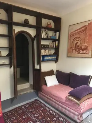 a living room with a couch and a book shelf at l'oasis de Bab Ghmat in Marrakech