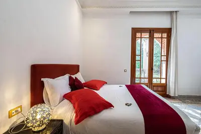 a bedroom with a large bed with red pillows at Palmeraie Collection Villa & Piscine in Marrakech