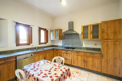 a kitchen with wooden cabinets and a table with a table cloth at Palmeraie Collection Villa & Piscine in Marrakech