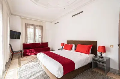 a bedroom with a large bed and a couch at Palmeraie Collection Villa & Piscine in Marrakech