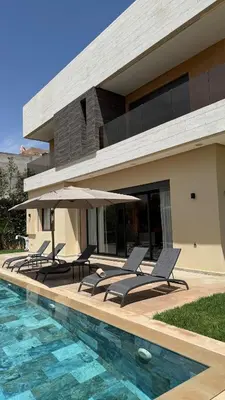 a house with a swimming pool next to a house at Exceptional Villa Noria Golf in Marrakech