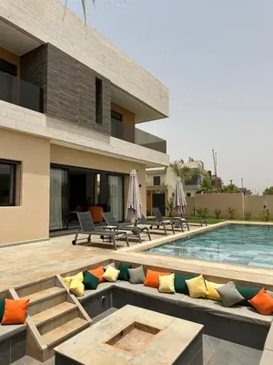 a villa with a swimming pool with a couch at Exceptional Villa Noria Golf in Marrakech