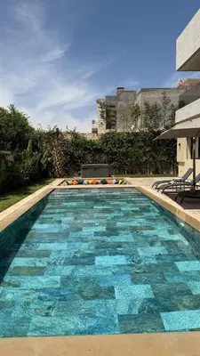 a large swimming pool with blue tiles on it at Exceptional Villa Noria Golf in Marrakech