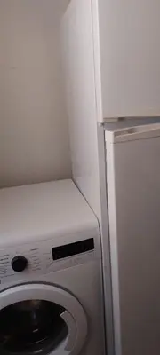 a white refrigerator and a washing machine in a room at Apartment near train station Marrakesh in Marrakech