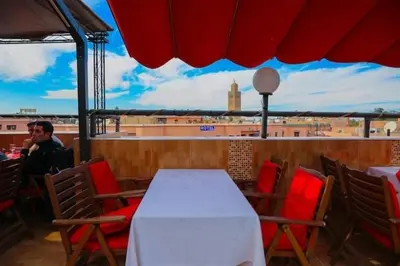 a table and chairs with a view of a city at GRAND HOTEL TAZi in Marrakech