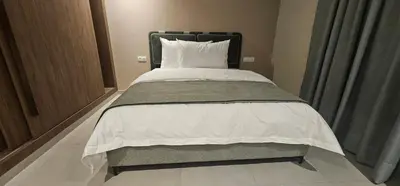 a bedroom with a bed with a white comforter at Muma Appartment in Marrakech