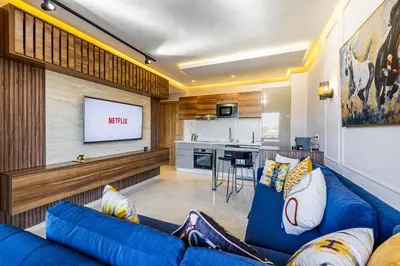 a living room with a blue couch and a tv at Noria Modern & Cozy Piscine in Marrakech