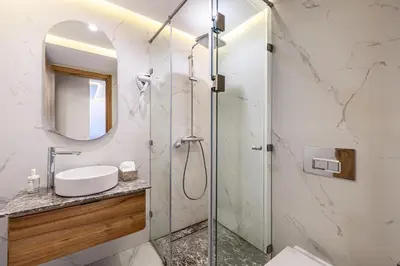a bathroom with a shower with a sink and a mirror at Noria Modern & Cozy Piscine in Marrakech