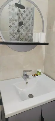 a white bathroom sink with a mirror and a sink at Appartement Serein 10 min jamaa el fnaaa in Marrakech