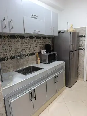 a kitchen with a sink and a refrigerator at Appartement Serein 10 min jamaa el fnaaa in Marrakech