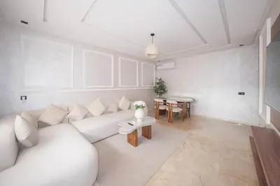 a living room with a white couch and a table at Modern apartments, cozy residence, swimming pools in Marrakech