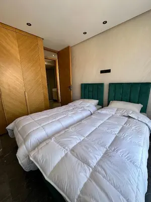a bedroom with two large beds with white sheets at new modern elite II apartment in Marrakech