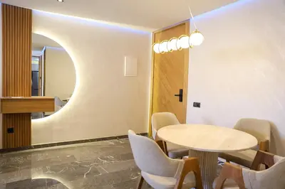 a dining room with a table and chairs and a mirror at new modern elite II apartment in Marrakech