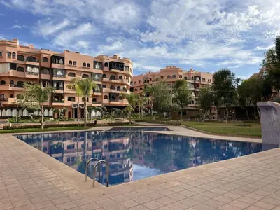 a swimming pool in front of a building at Appartement de Luxe Piscines et Jardins in Marrakech
