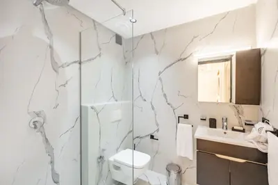 a bathroom with a shower and a toilet and a sink at Luxury Apartment In Majorelle Downtown Speed Wi-Fi and AC Calm in Marrakech