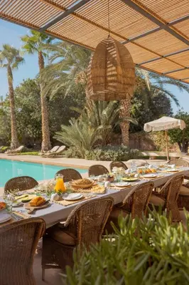 a long table with food on it next to a pool at Villa Primerose in Marrakech