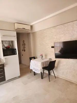 a kitchen with a table with chairs and a refrigerator at Le Cosy Carré Éden - Hypercentre Gueliz in Marrakech