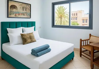 a bedroom with a large bed with a chair and a window at Appart du centre 9 in Marrakech