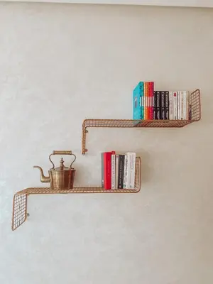 a shelf with books and a tea pot on a wall at Central Station Cosy Studio in Marrakech
