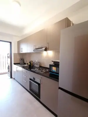 a kitchen with a stove and a refrigerator at Luxueux Appartement rez-de-chaussée Noria Golf in Marrakech