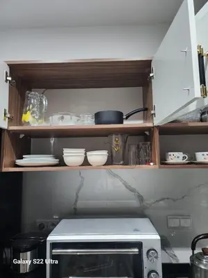 a kitchen shelf with a microwave and dishes on it at Chic Urban Retreat Bright Apartment in Targa in Marrakech