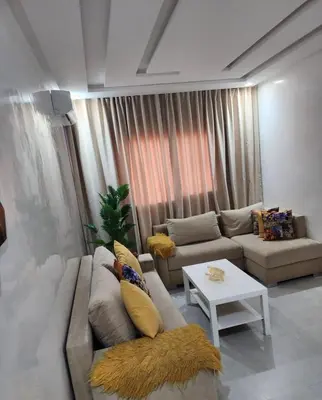 a living room with a couch and a table at Chic Urban Retreat Bright Apartment in Targa in Marrakech