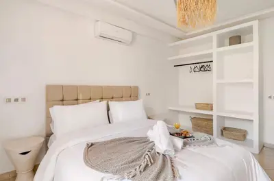 a white bedroom with a large white bed with a blanket at Rental unit in Marrakech in Marrakech