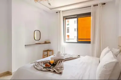a white bedroom with a tray of food on a bed at Rental unit in Marrakech in Marrakech