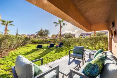 a patio with a couch and chairs on a deck at Familial appt-Prestigia- 2BR-Pool-Free parking in Marrakech