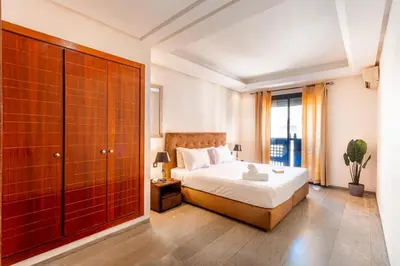 a bedroom with a bed and a large window at Menara gardens in Marrakech