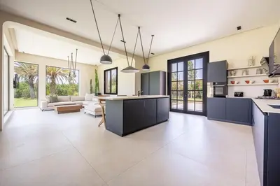an open kitchen and living room with blue cabinets at MIKESTAY Domaine ATIKA in Segraga