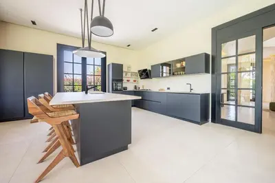 a kitchen with black cabinets and a white counter top at MIKESTAY Domaine ATIKA in Segraga