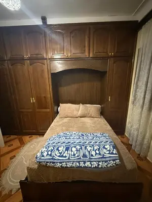 a bed in a room with wooden cabinets at Yassine in Marrakech