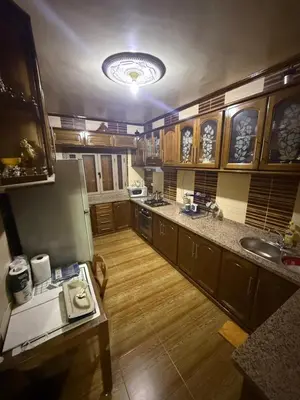 a large kitchen with wooden floors and a refrigerator at Yassine in Marrakech
