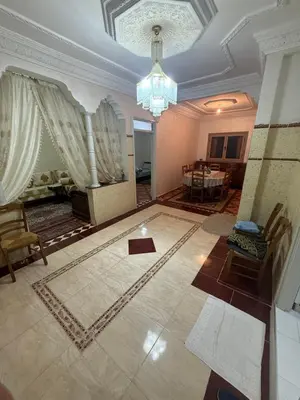 a living room with a chandelier and a dining room at Yassine in Marrakech