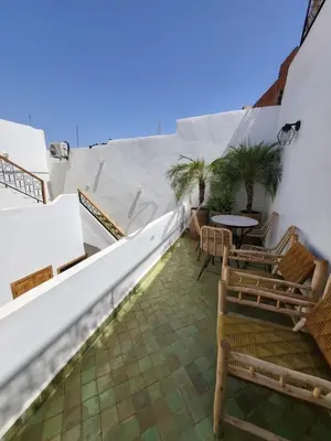 a balcony with chairs and a table and palm trees at Riad in Marrakech