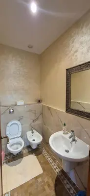 a bathroom with a sink and a toilet and a mirror at Luxe & calme Palmeraie terrasse piscine in Marrakech
