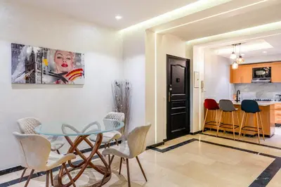 a dining room with a glass table and chairs at Bright & Airy Modern Flat in heart of Marrakech in Marrakech
