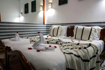a group of three beds with swans on them at Riad Allal in Marrakech