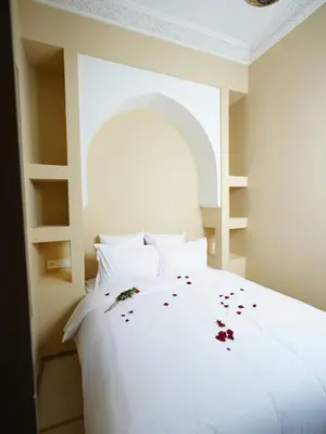 a white bed with flower petals on it at Riad privatif Les Tamaris in Marrakech