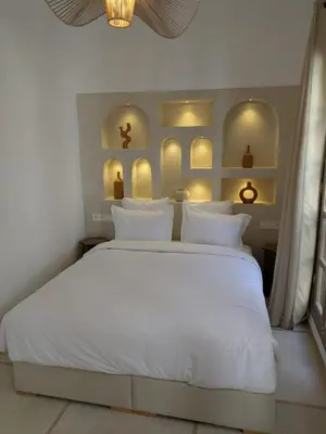 a white bed with white pillows in a bedroom at Riad privatif Les Tamaris in Marrakech