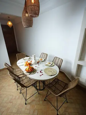 a dining room table with chairs and a plate of food at Riad privatif Les Ibéris in Marrakech