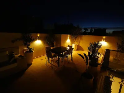 a patio with a table and chairs at night at Riad privatif Les Ibéris in Marrakech