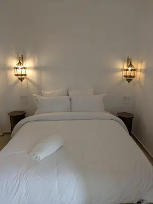 a white bed with two lights on top of it at Riad privatif Les Ibéris in Marrakech