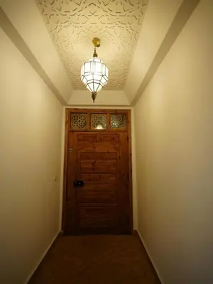 a room with a wooden door and a chandelier at Riad privatif Les Ibéris in Marrakech