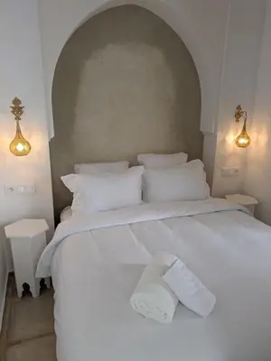a large white bed with two white towels on it at Riad privatif Les Ibéris in Marrakech