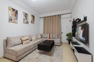 a living room with a couch and a flat screen tv at Appartement 2 chambres avec terrasse ensoleillée in Marrakech