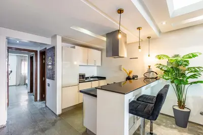 a kitchen with white cabinets and a black counter top at superbe appartement au coeur de guiliz - victor Hugo in Marrakech